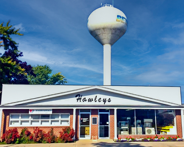 A photo of Hawleys Inc headquarters with a white Benson, Minnesota water tower in the background.
